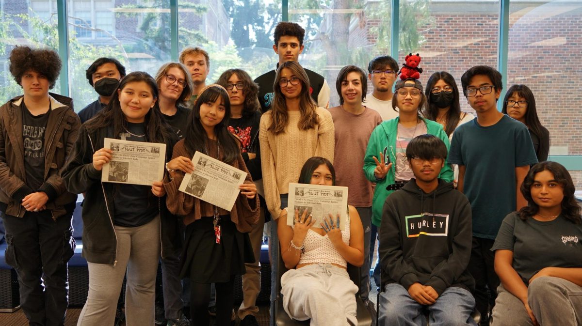 Blue Tide staff photo holding a copy of the last Blue Tide paper printed on September 10, 2014.  