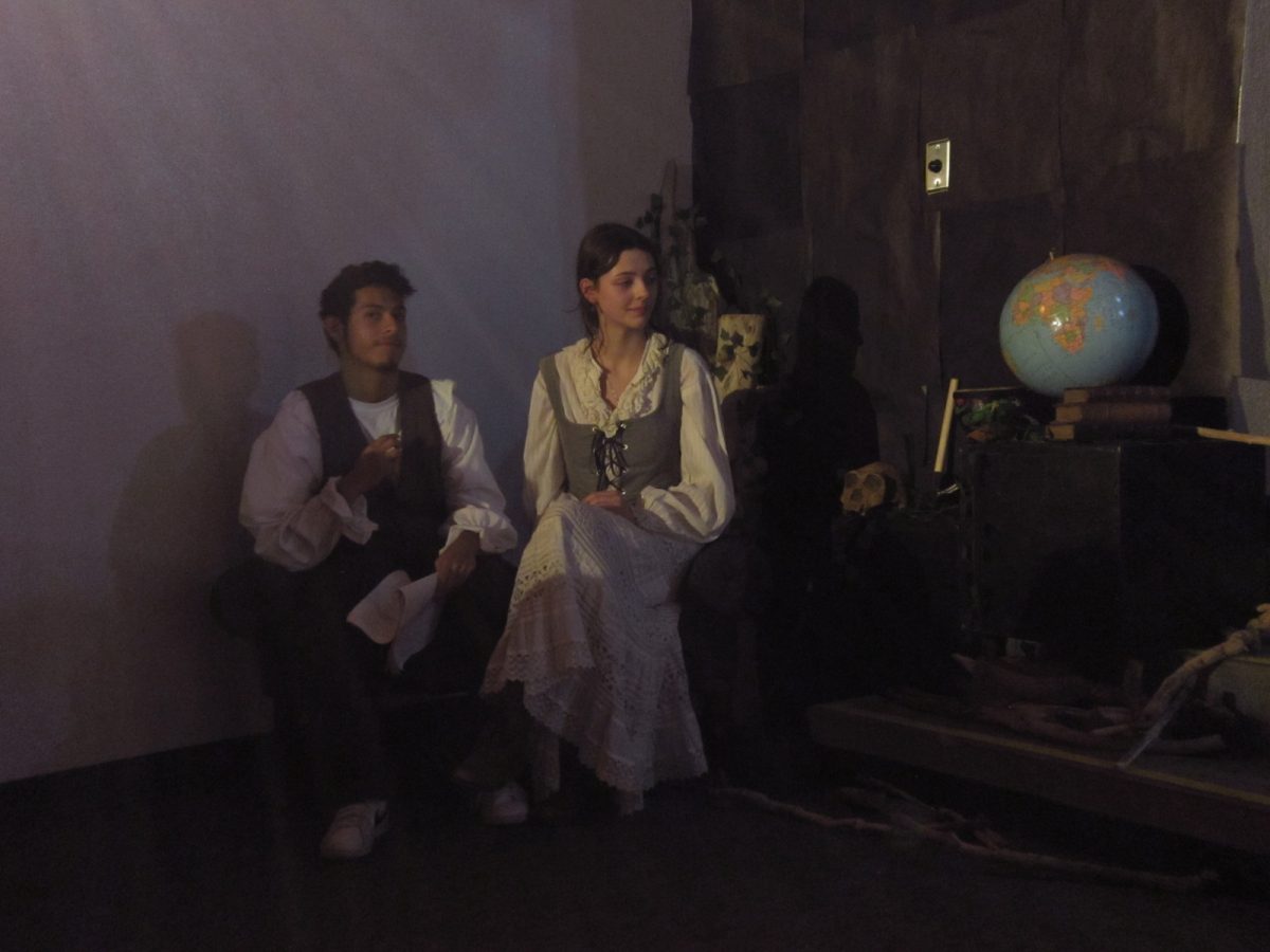 Ferdinand (played by Sebastian Ramirez) pictured left and Miranda (played by Magnolia Wallace) pictured right sitting down together.