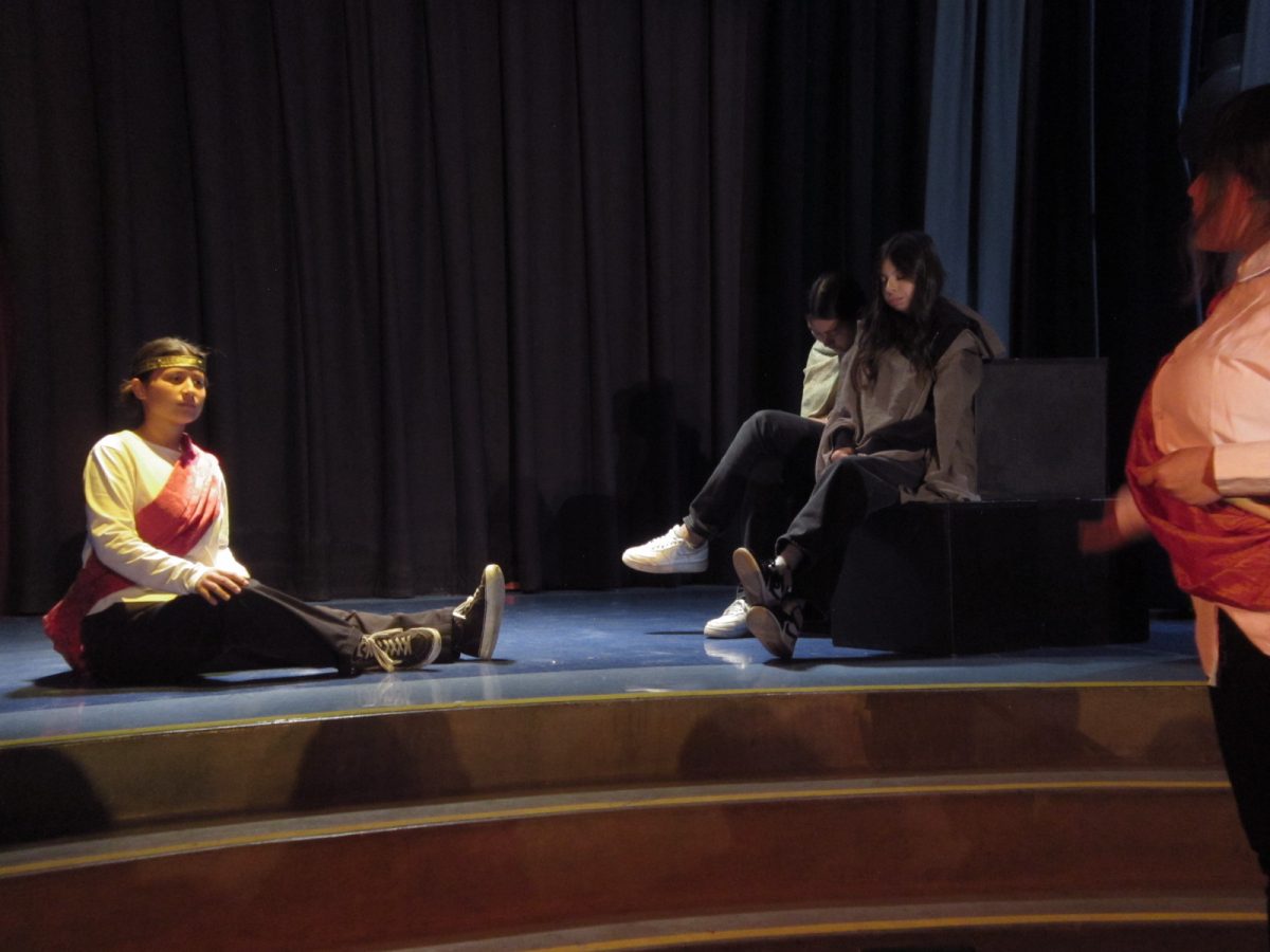 The king of Naples, Alonzo (played by Angelina Valencia) pictured left with Gonzalo (played by Fabiola Fuentes) and Adrian (Mia Esparza) sitting on blocks and Sebastian (Itzeli Cervantes) pictured right.