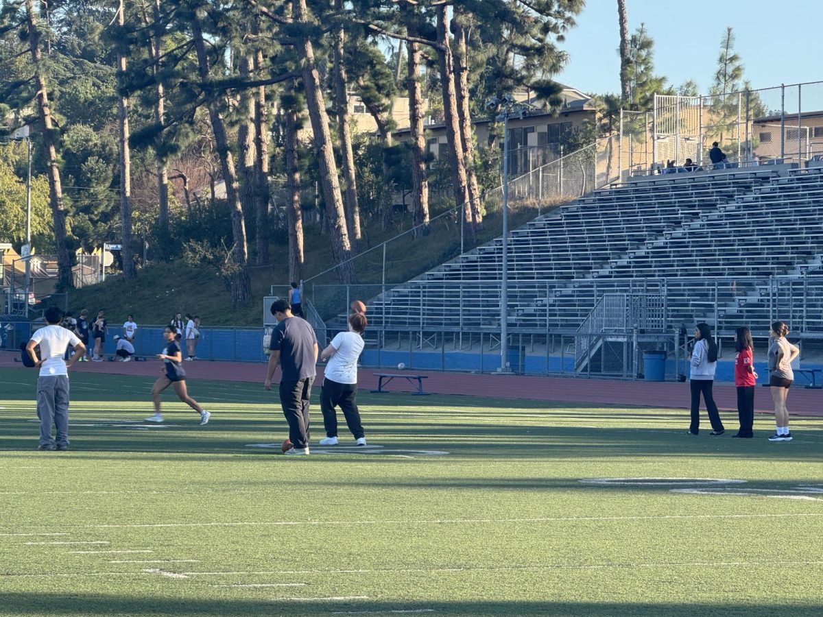 Powderpuff participants practice catching footballs.