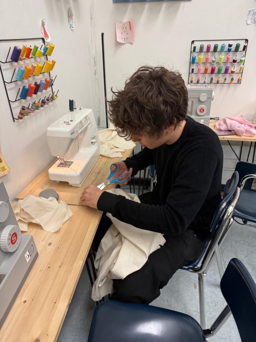 Ryden Robledo works on a jacket for the end-of-semester fashion show. 