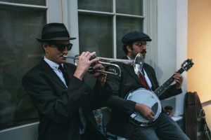 https://www.pexels.com/photo/a-man-in-black-suit-playing-trumpet-beside-man-playing-banjo-9213701/